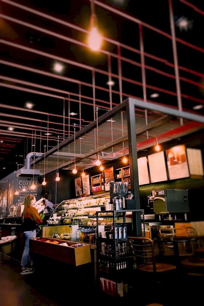 Warm and inviting café interior with modern lighting and seating. Perfect for a relaxing coffee break.